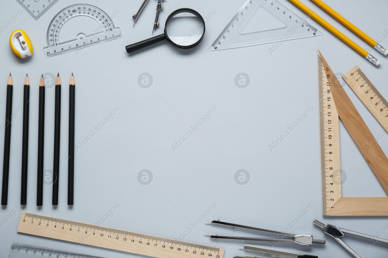 Photo of Flat lay composition with different rulers and compasses on light grey background. Space for text