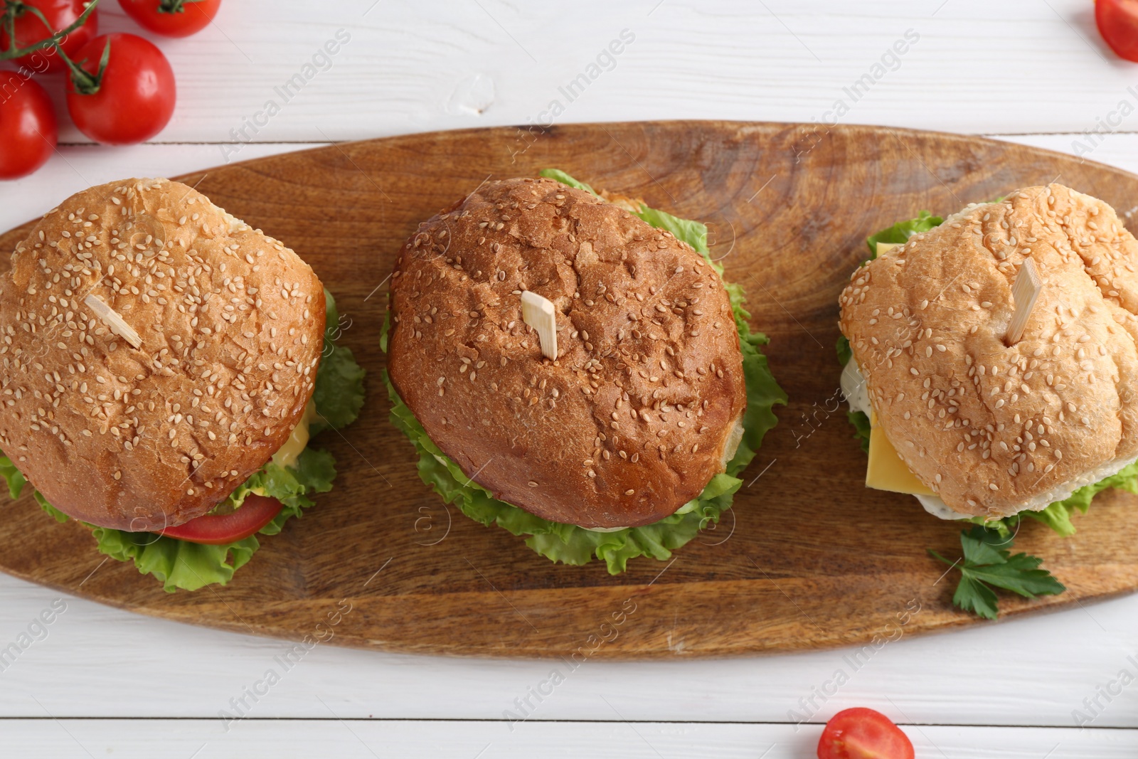 Photo of Delicious vegetarian burgers served on white wooden table, top view