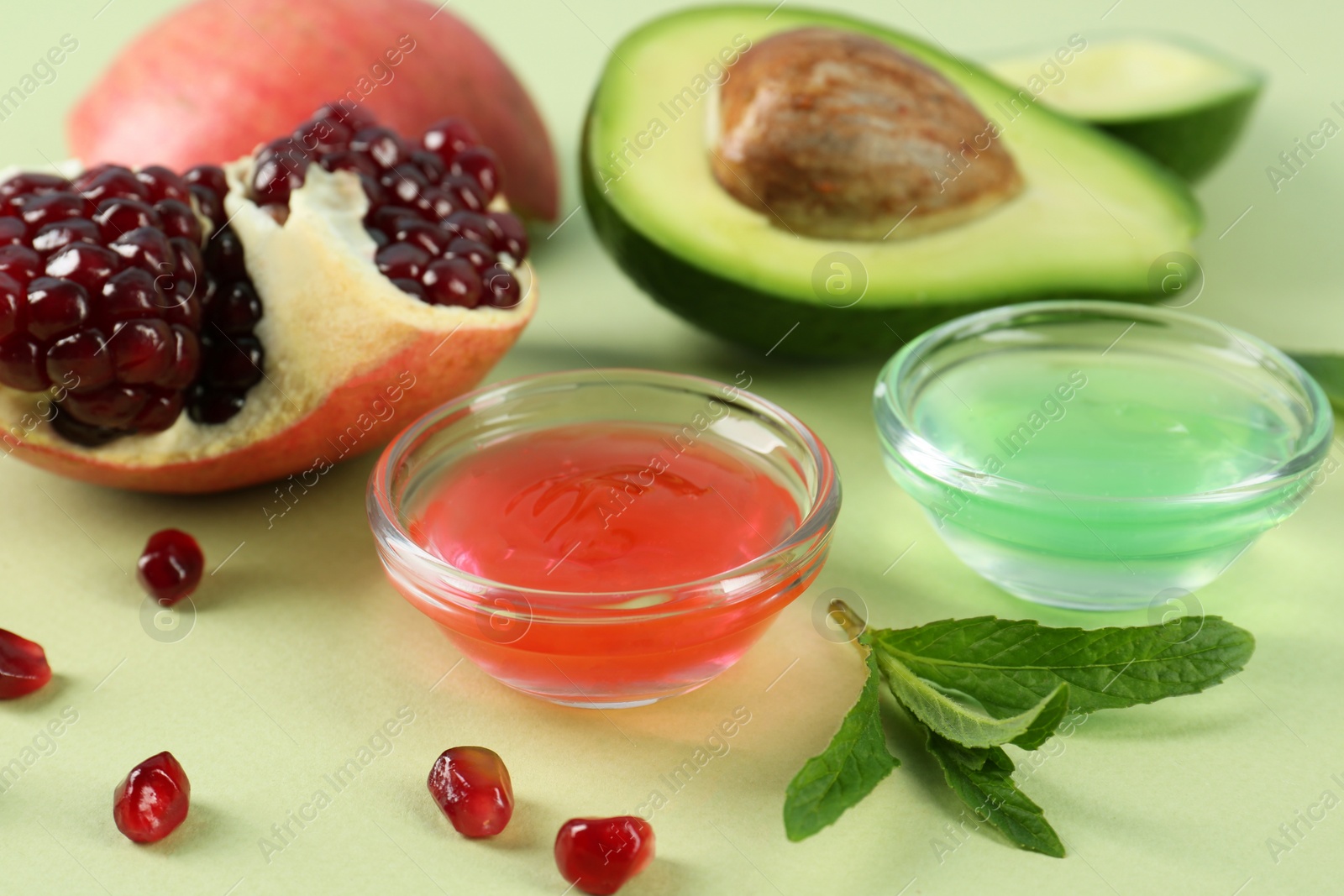 Photo of Homemade cosmetic products and fresh ingredients on light green background, closeup. DIY beauty recipe