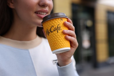 Lviv, Ukraine - September 26, 2023: Woman with hot McDonald's drink outdoors, closeup. Space for text