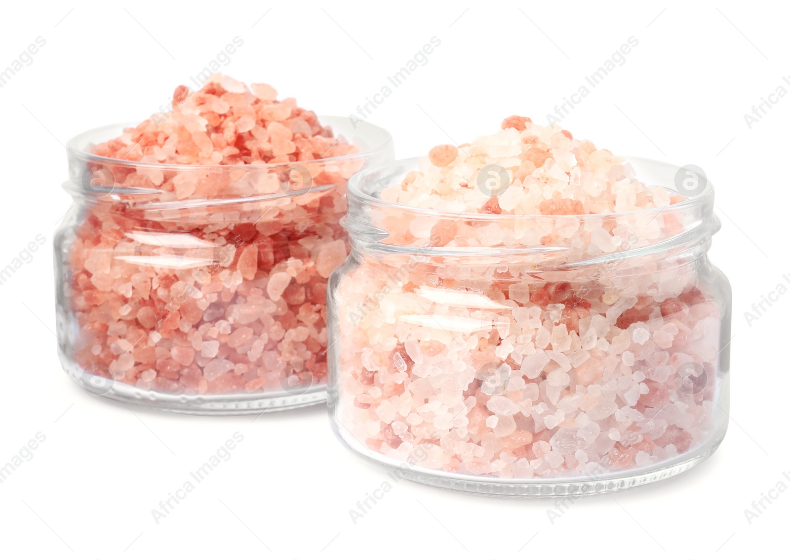 Photo of Glass jars with natural sea salt on white background