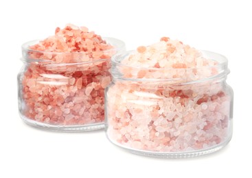 Photo of Glass jars with natural sea salt on white background