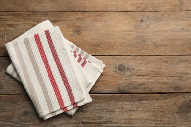 Striped kitchen towels on wooden table, top view. Space for text