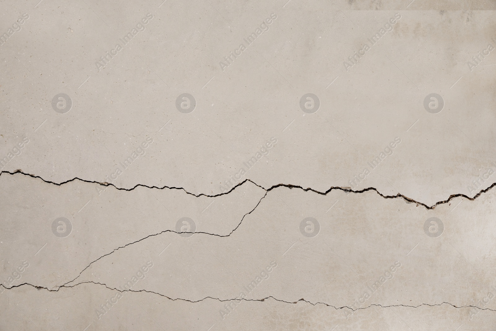 Photo of Concrete surface with cracks as background, closeup