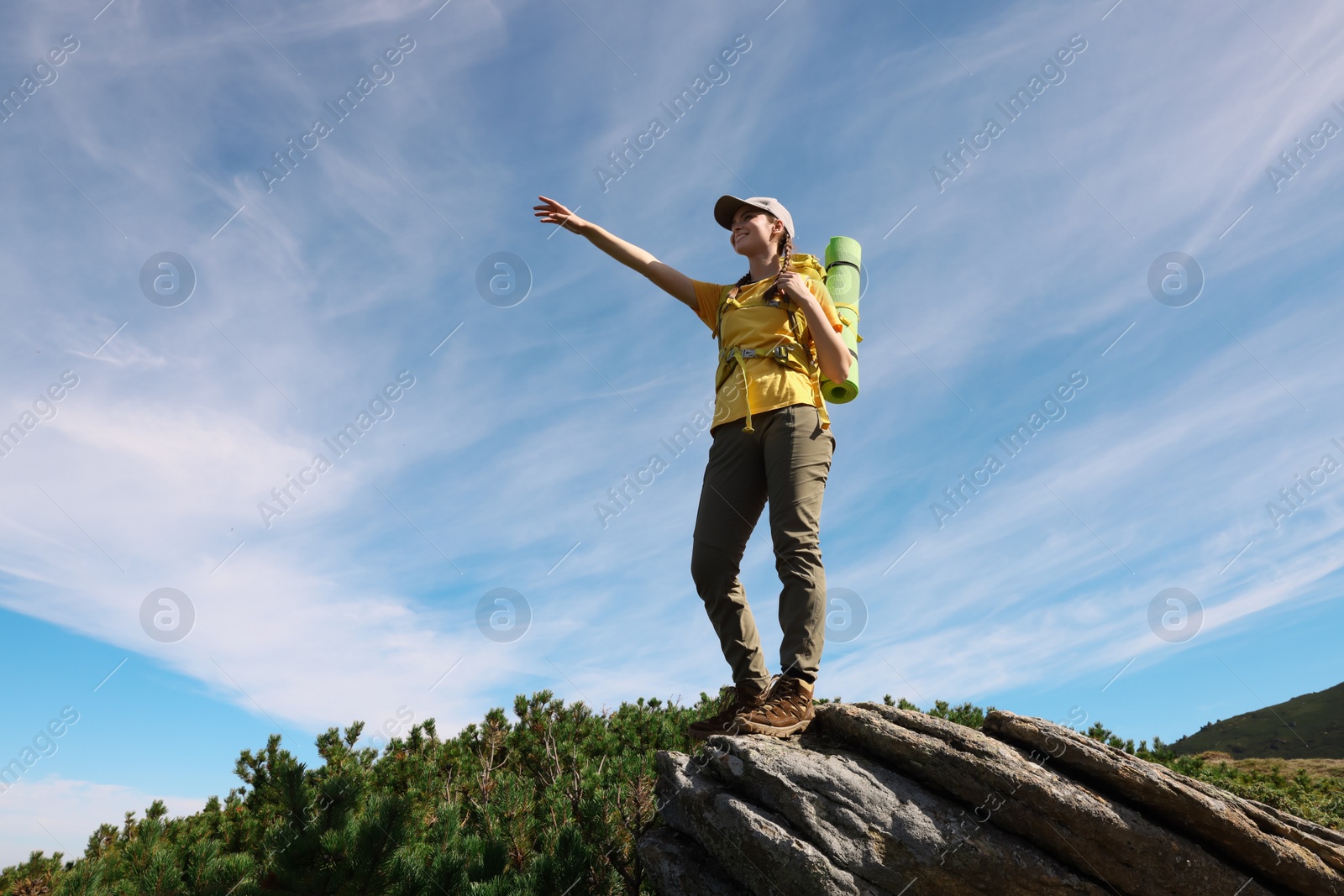 Photo of Young woman with backpack in mountains. Space for text