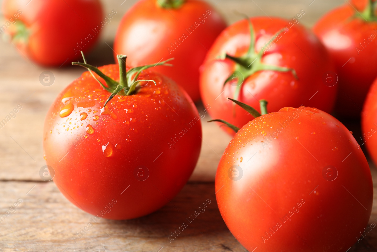 Photo of Fresh ripe tomatoes on wooden table, closeup