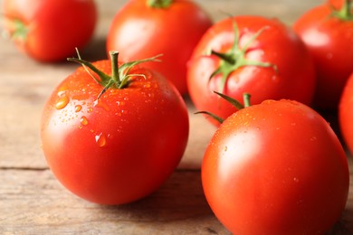 Fresh ripe tomatoes on wooden table, closeup