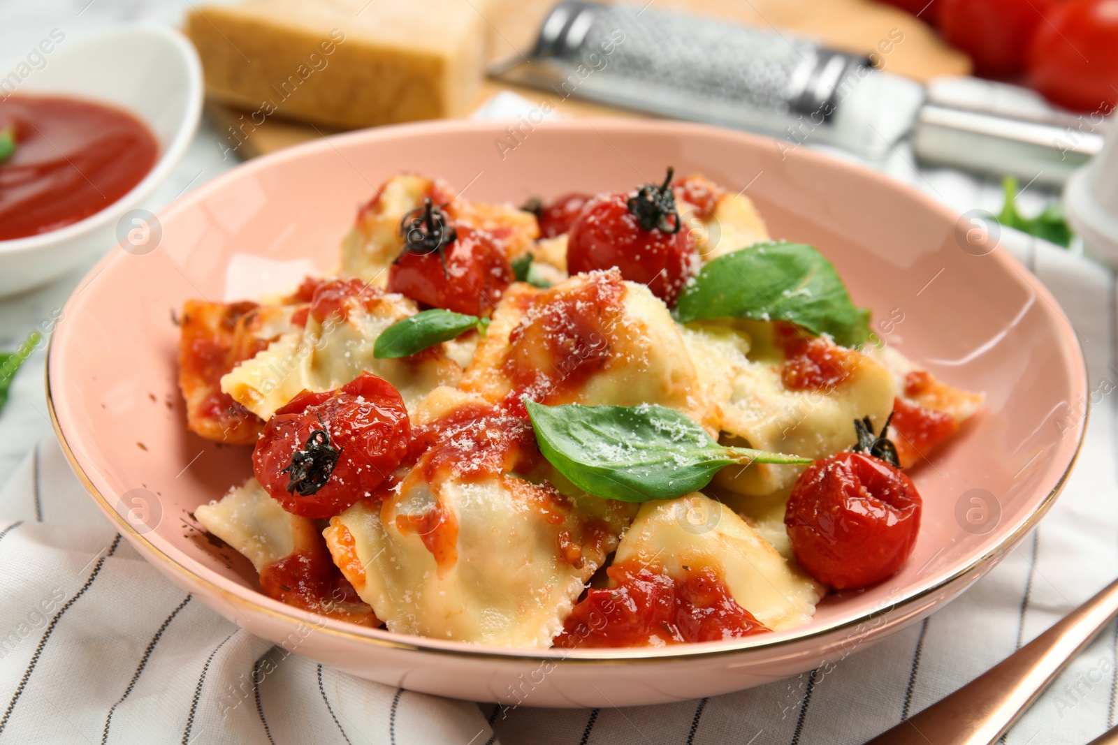 Photo of Tasty ravioli with tomato sauce served on table, closeup