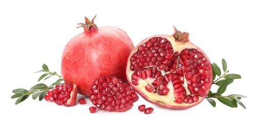 Photo of Fresh pomegranates and branches isolated on white