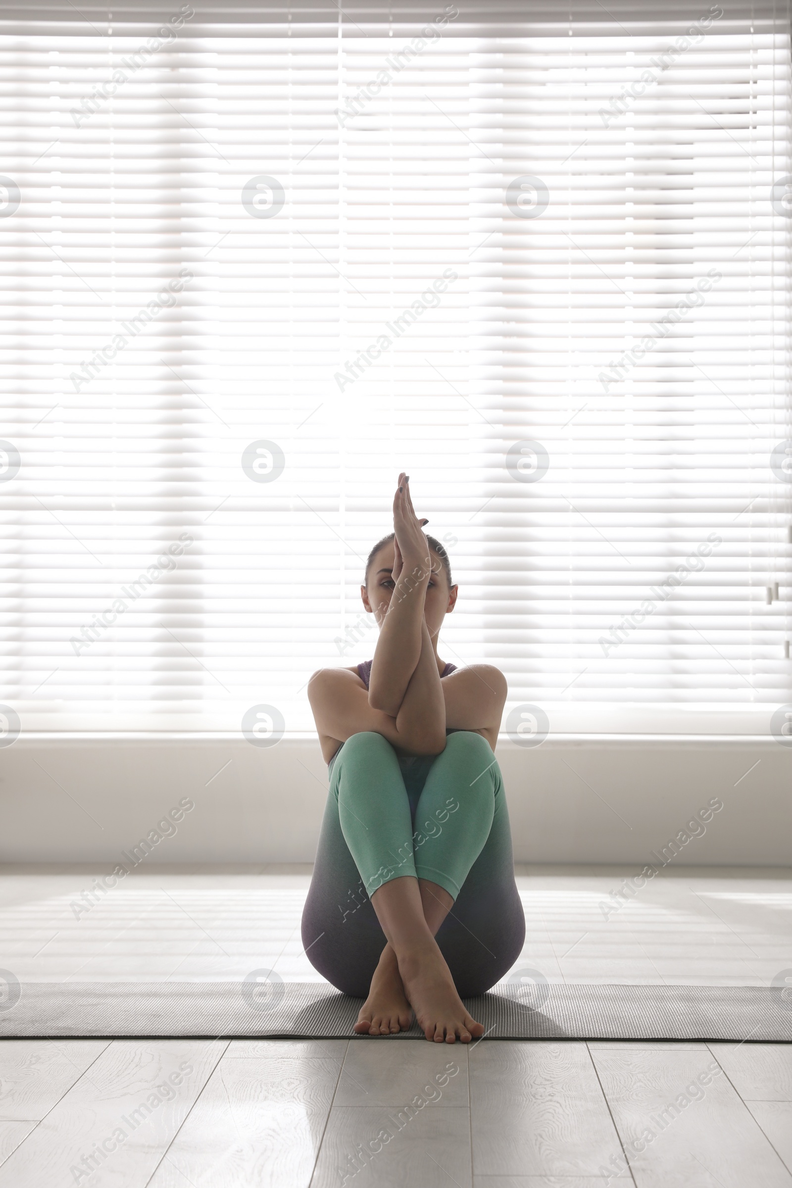 Photo of Woman practicing eagle asana in yoga studio. Garudasana pose