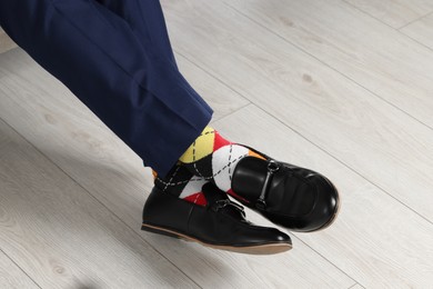 Man wearing stylish shoes and colorful socks indoors, closeup