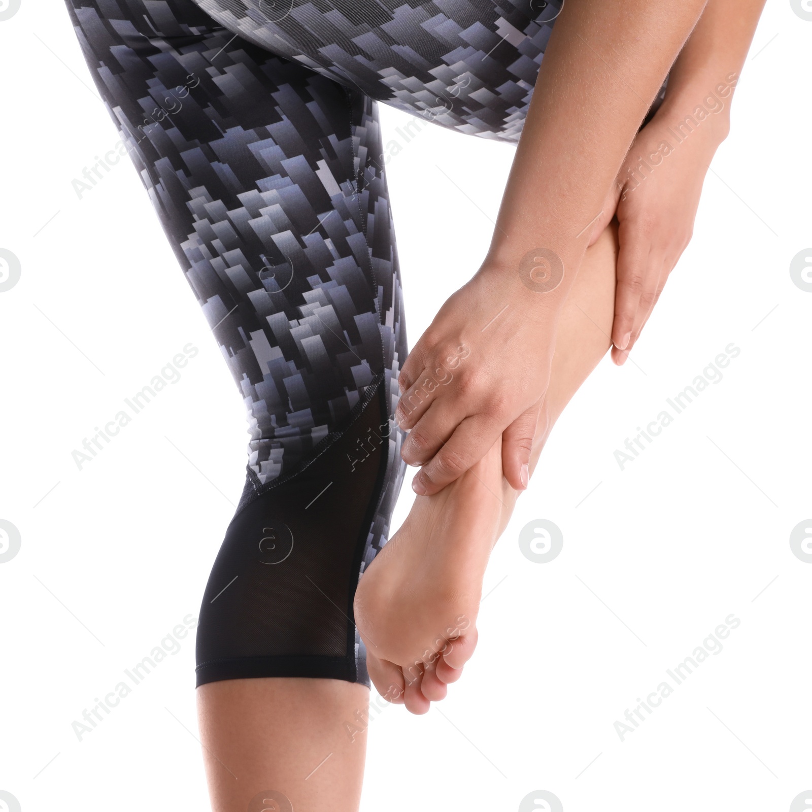 Photo of Young woman suffering from pain in foot on white background, closeup