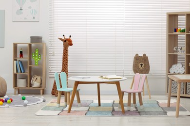 Photo of Child`s playroom with different toys and modern furniture. Stylish kindergarten interior