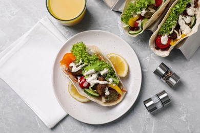 Photo of Delicious fresh vegan tacos served on light grey marble table, flat lay
