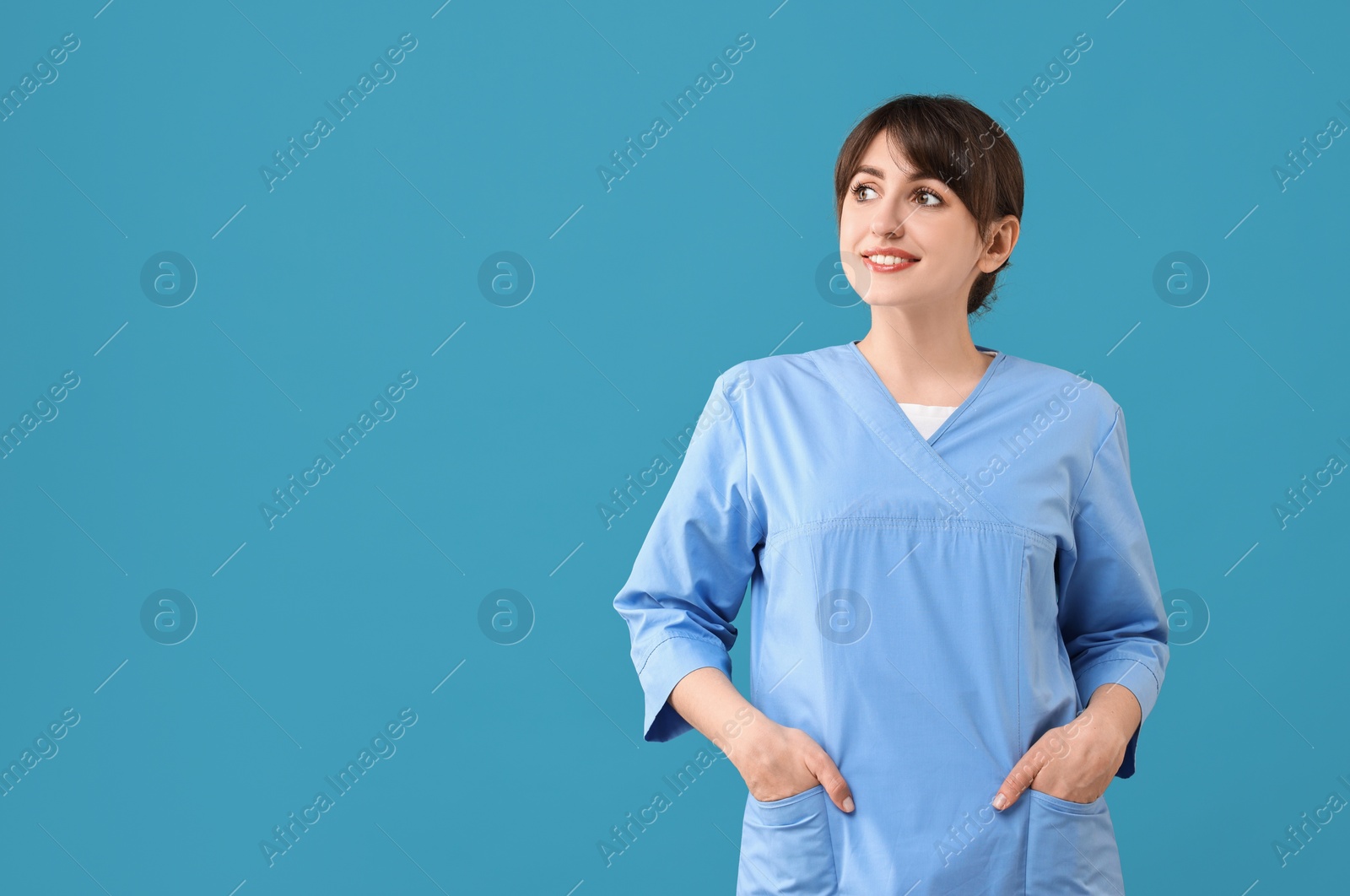 Photo of Portrait of smiling medical assistant on light blue background. Space for text