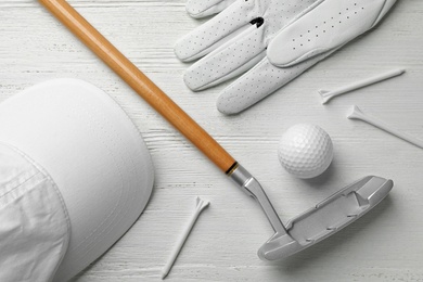 Photo of Flat lay composition with golf accessories on white wooden background