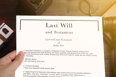 Image of Woman holding Last Will and Testament at table, top view