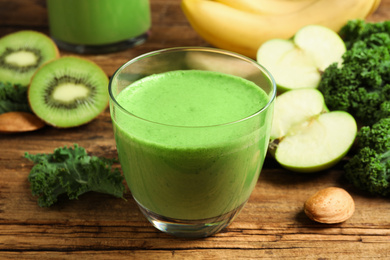 Photo of Tasty fresh kale smoothie on wooden table, closeup