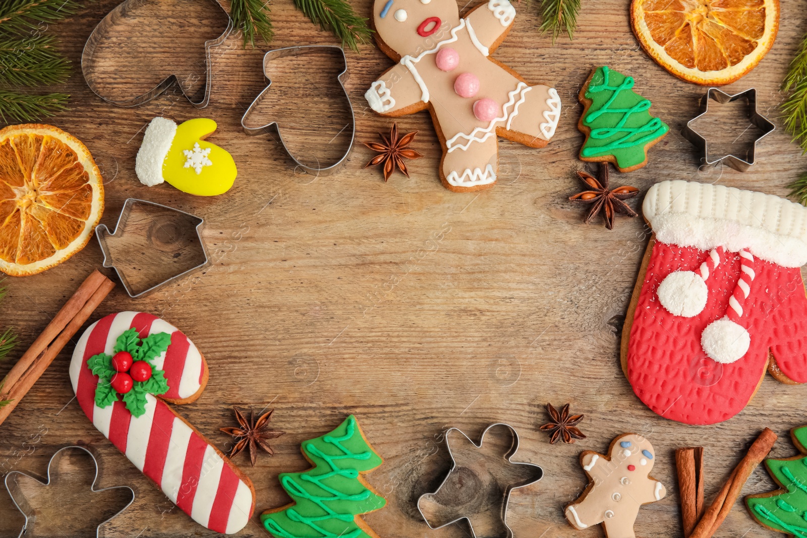 Photo of Flat lay composition with Christmas biscuits and cookie cutters on wooden table. Space for text.