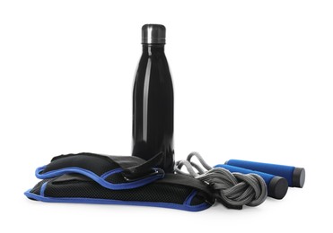 Photo of Stylish weighting agents, skipping rope and sport bottle on white background