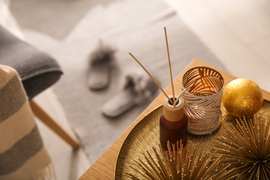 Elegant Christmas decor and reed diffuser on table indoors. Interior design