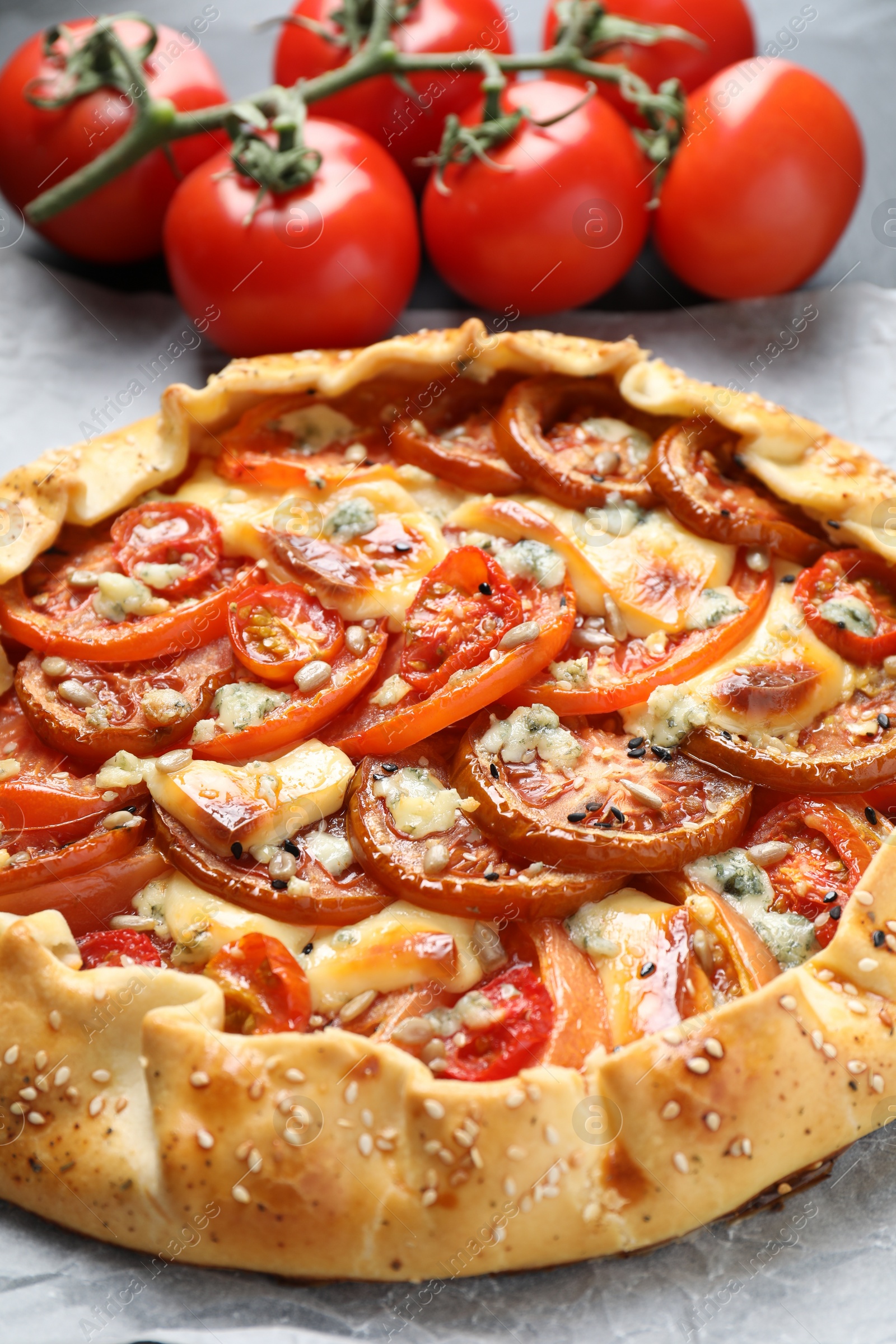 Photo of Tasty galette with tomato and cheese (Caprese galette) on table, closeup