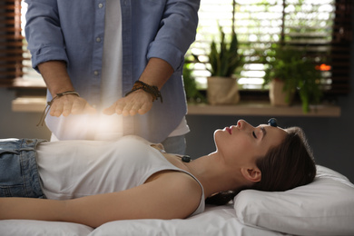 Photo of Young woman during crystal healing session in therapy room