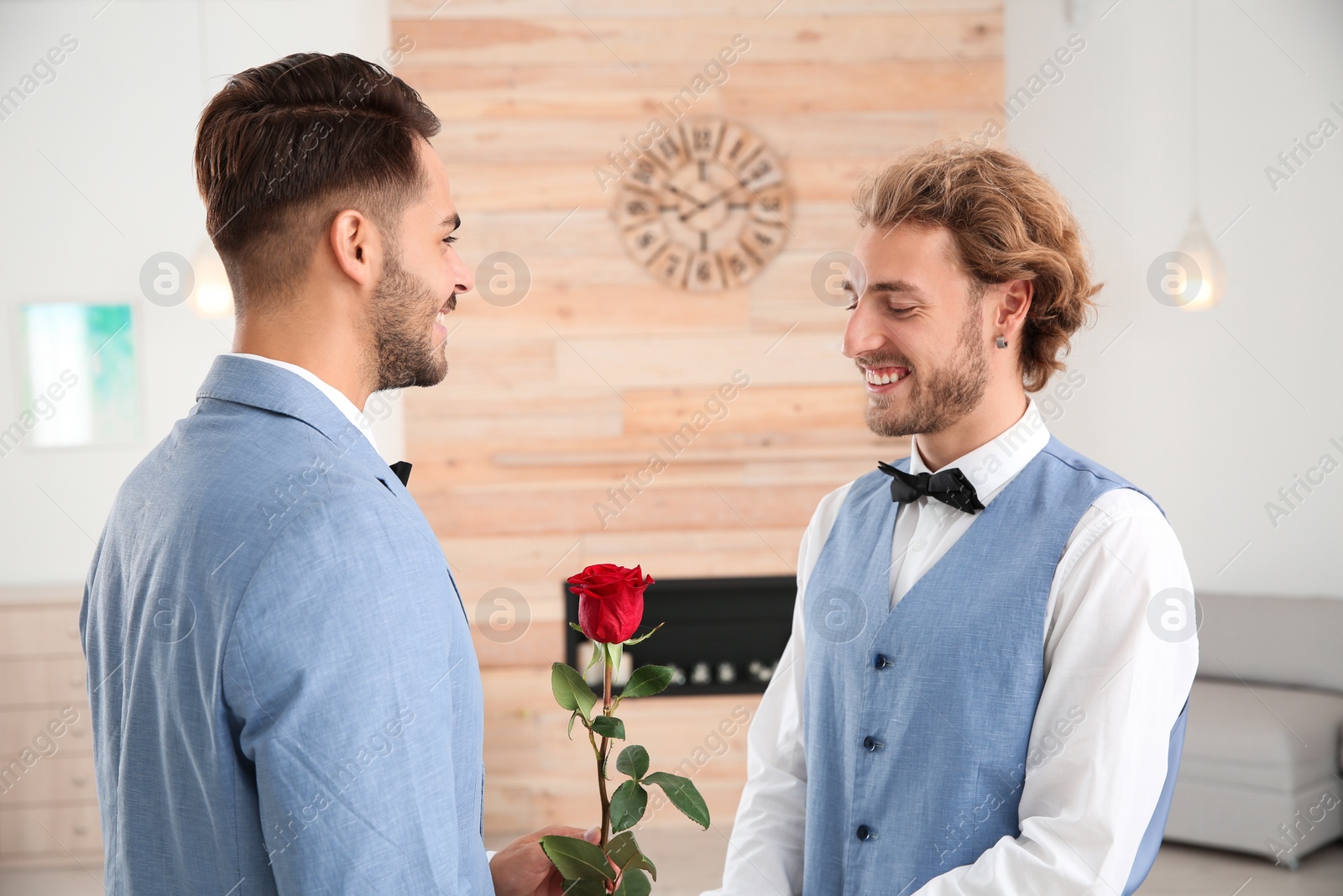 Photo of Happy newlywed gay couple with flower at home