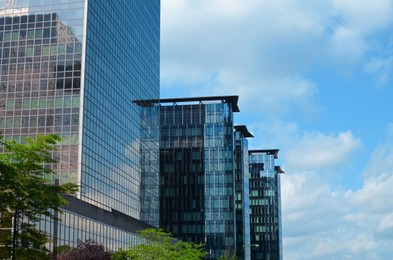 Photo of Skyscrapers in city center on sunny day. Modern architectural design