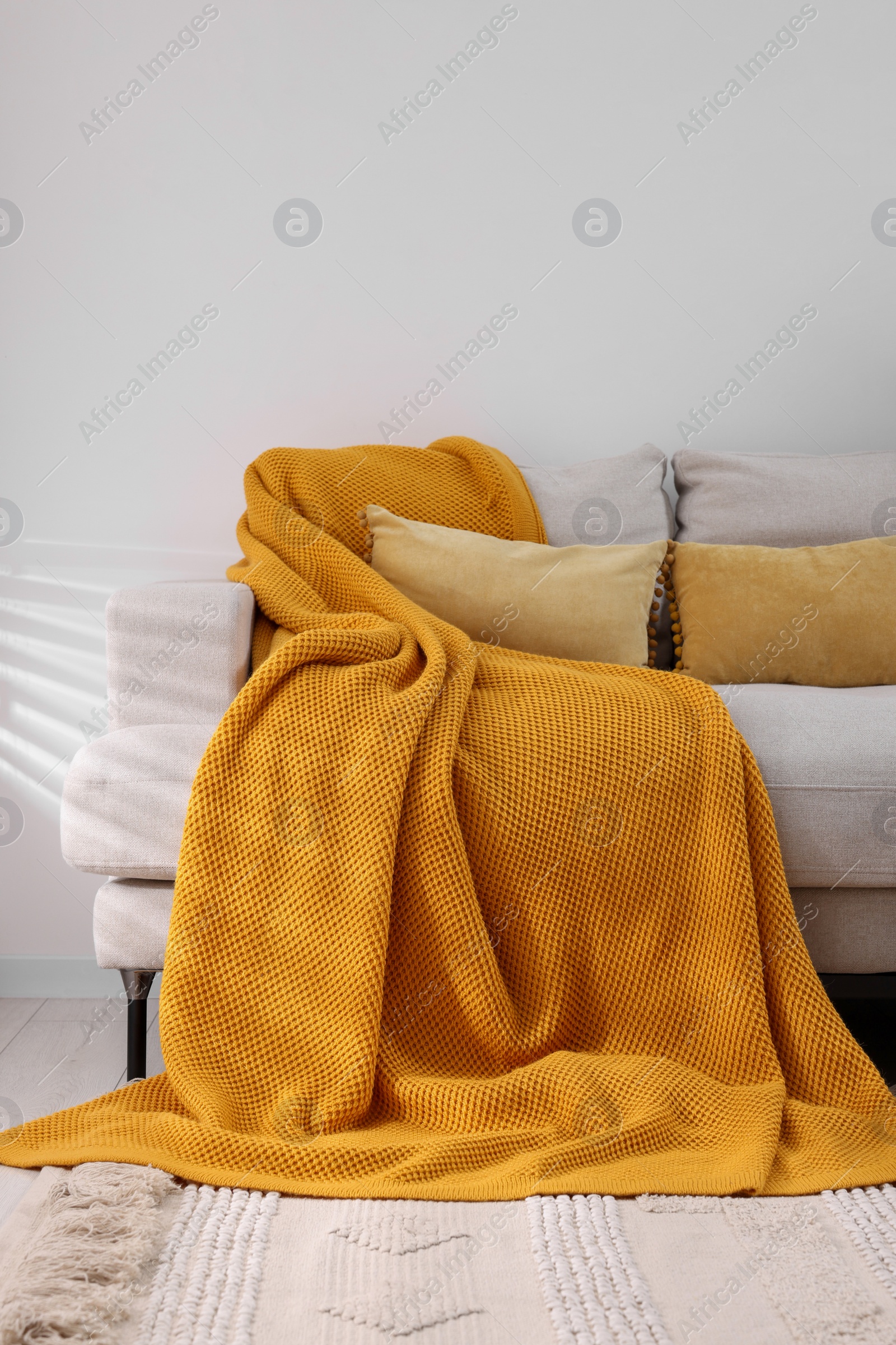 Photo of Cozy orange plaid on sofa in room