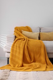 Photo of Cozy orange plaid on sofa in room