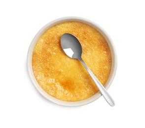 Photo of Delicious creme brulee and spoon in ceramic ramekin isolated on white, top view