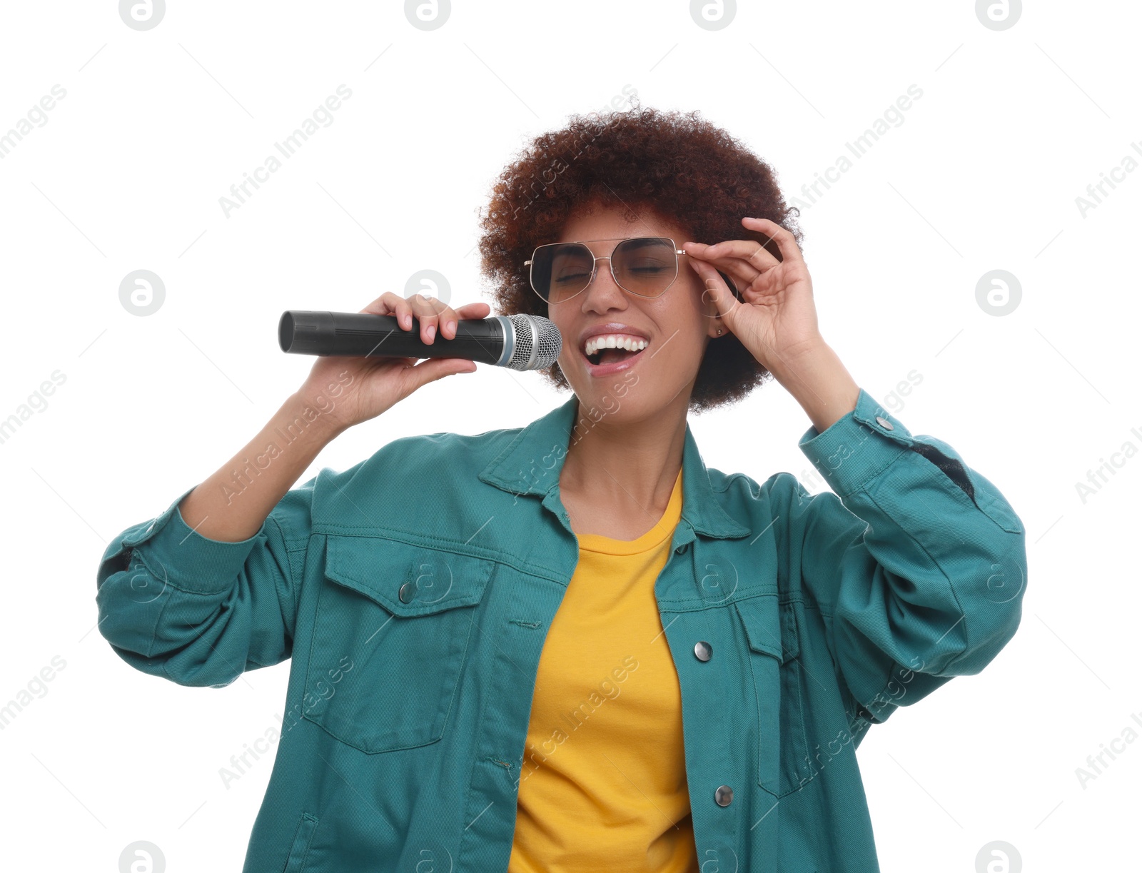 Photo of Curly young woman in sunglasses with microphone singing on white background