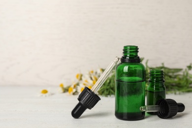 Composition with bottles of chamomile essential oil on table. Space for text