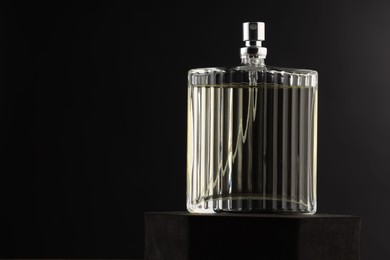 Photo of Luxury men`s perfume in bottle against dark background, space for text