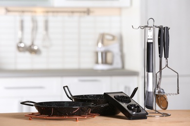 Photo of Set of clean cookware and utensils on table in kitchen. Space for text