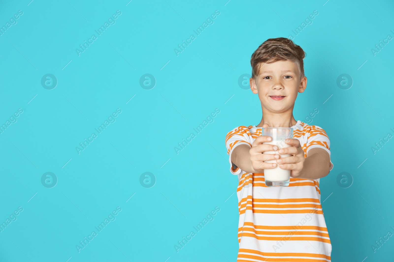 Photo of Adorable little boy with glass of milk on color background