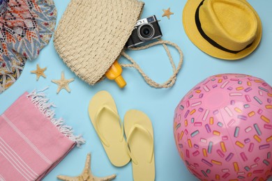 Photo of Flat lay composition with beach ball on light blue background