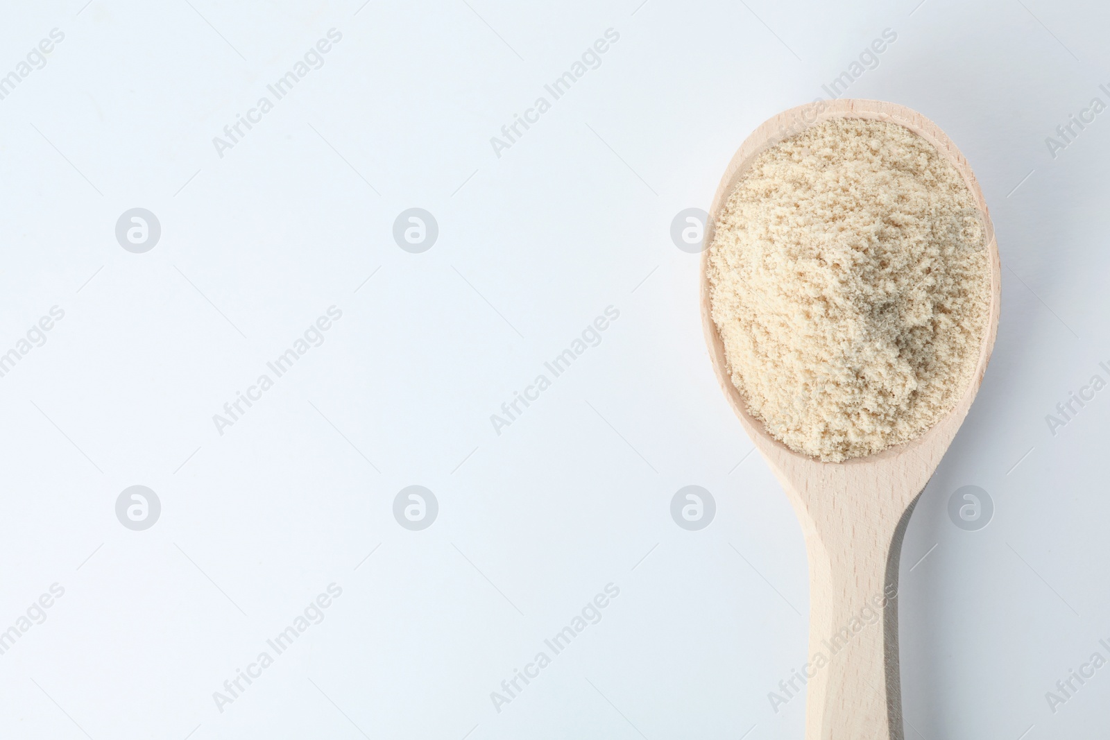 Photo of Spoon of sesame flour isolated on white, top view with space for text