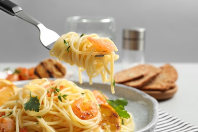 Photo of Eating of delicious pasta with shrimp, closeup
