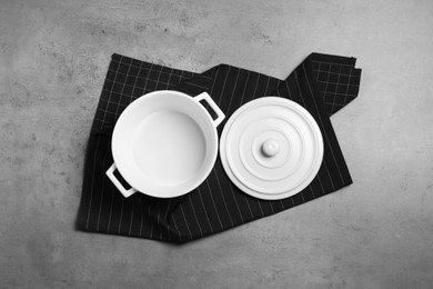 Photo of One empty ceramic pot and lid on grey textured table, top view