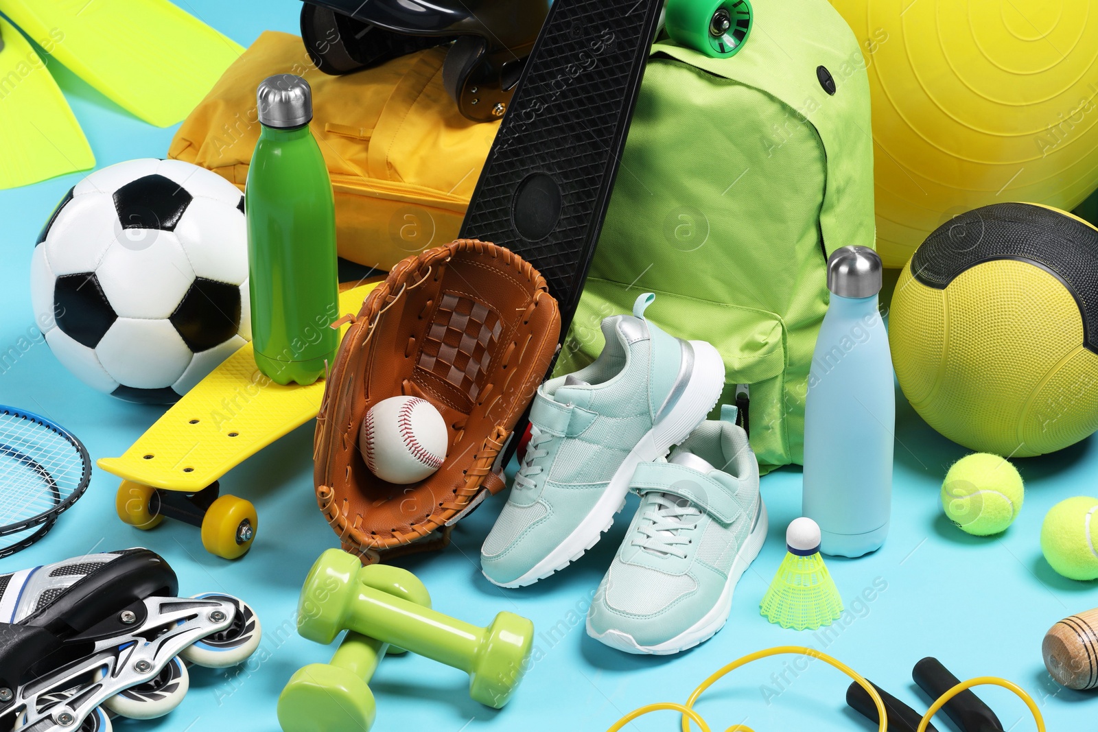 Photo of Many different sports equipment on light blue background, closeup