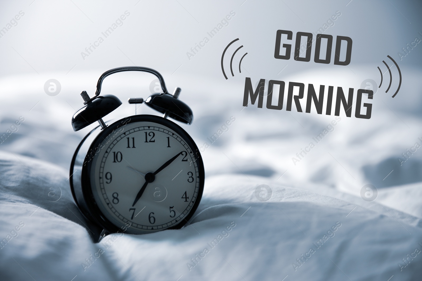 Image of Good Morning! Black alarm clock on bed