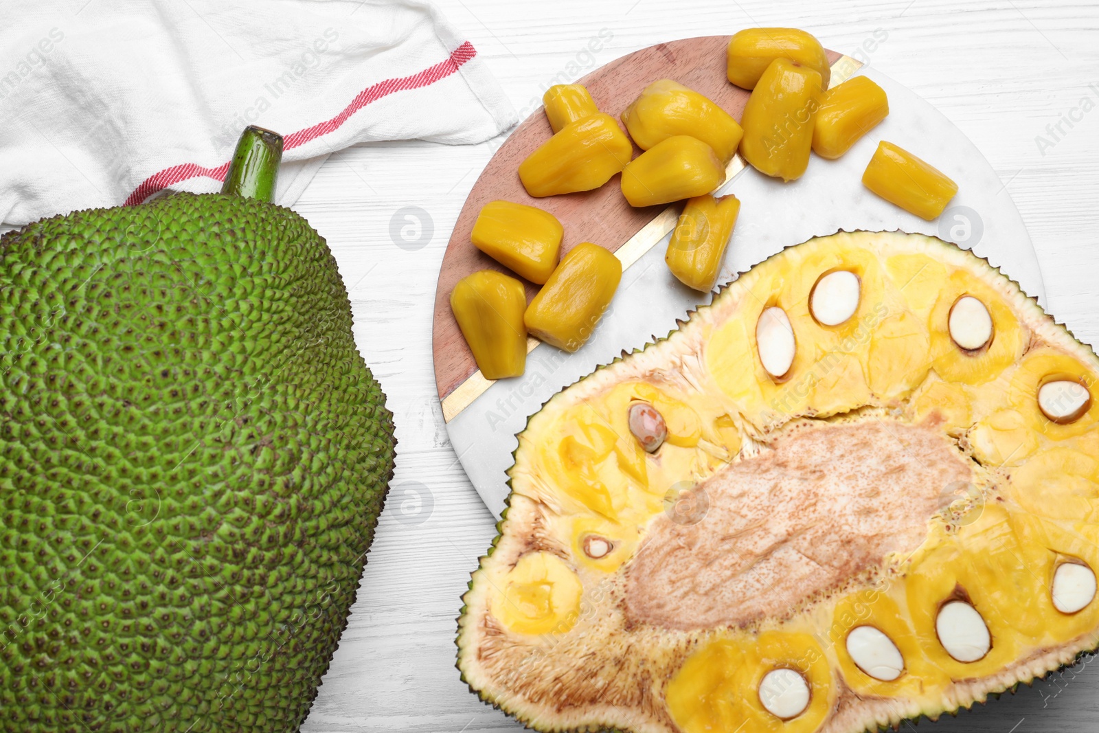 Photo of Delicious exotic jackfruits on white wooden table, flat lay