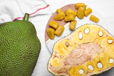 Delicious exotic jackfruits on white wooden table, flat lay