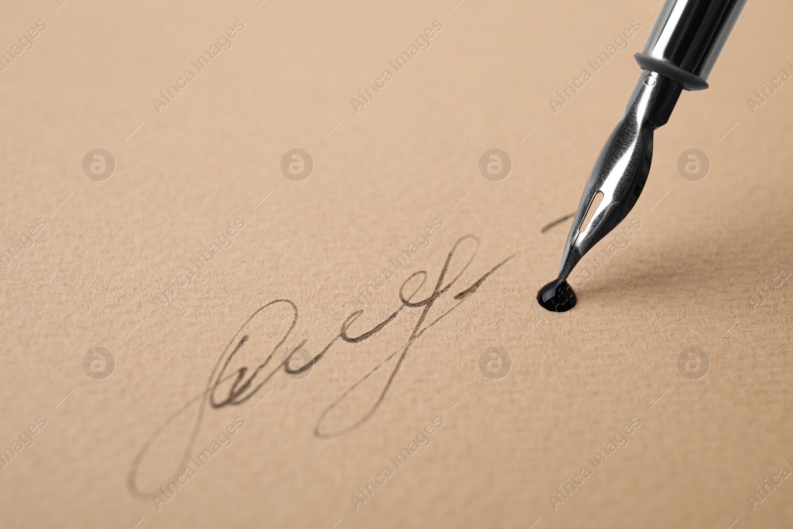 Photo of Signing on sheet of paper with fountain pen, closeup. Space for text