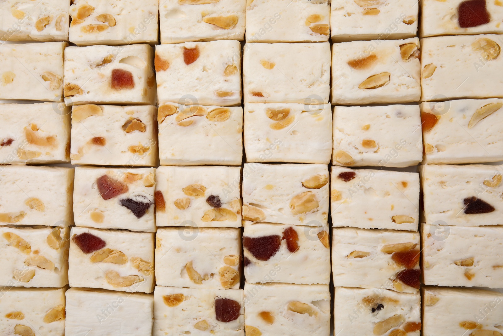 Photo of Pieces of delicious nougat as background, top view