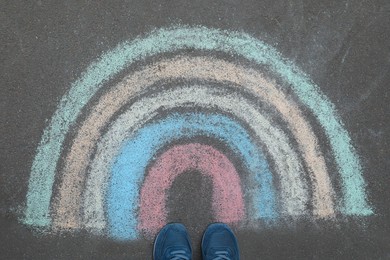 Woman near rainbow drawn with chalk on asphalt, above view