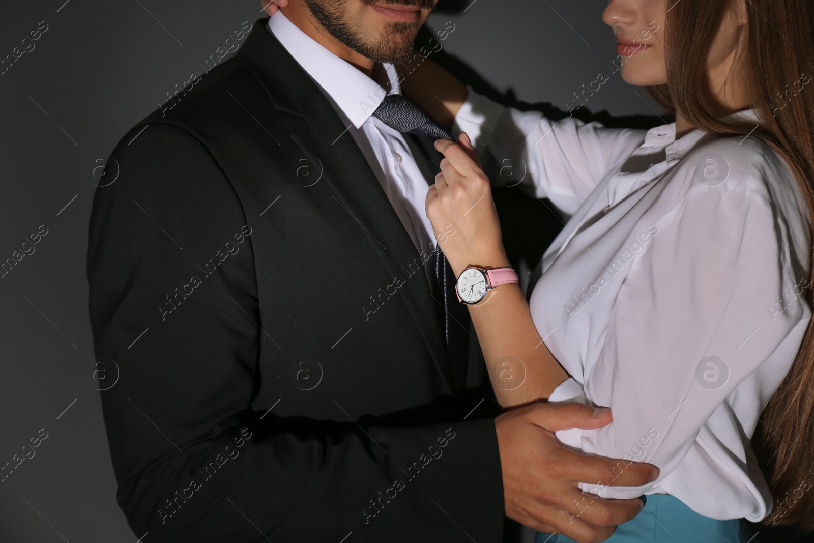 Photo of Woman molesting her male colleague on dark background, closeup. Sexual harassment at work