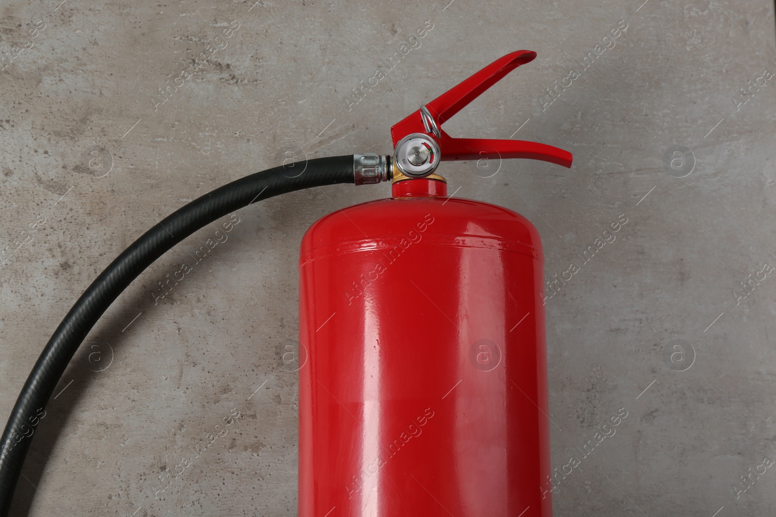 Photo of Fire extinguisher on light grey stone background, top view